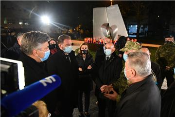 Molitva i paljenje svijeća ispred Nacionalne memorijalne bolnice Vukovar