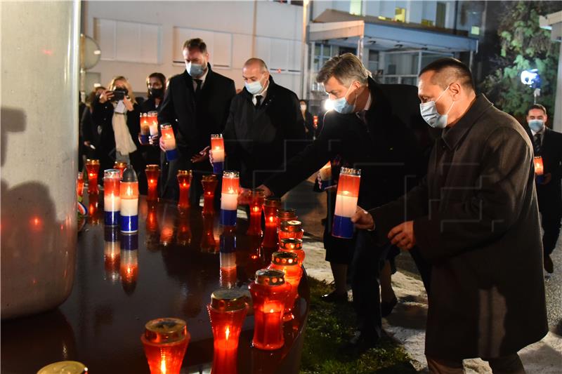 Molitva i paljenje svijeća ispred Nacionalne memorijalne bolnice Vukovar