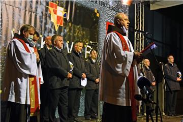 Molitva i paljenje svijeća ispred Nacionalne memorijalne bolnice Vukovar