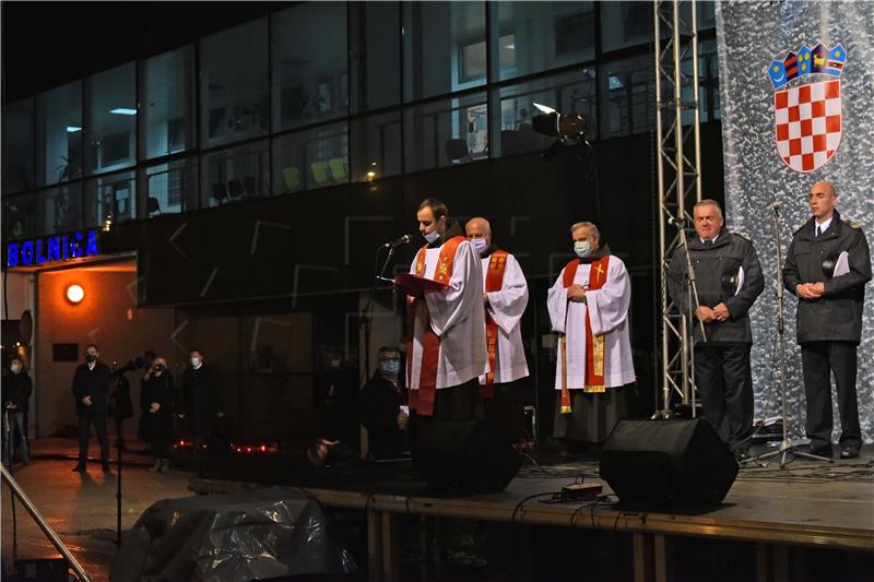 Molitva i paljenje svijeća ispred Nacionalne memorijalne bolnice Vukovar